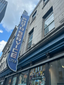 The sign Photo Service Ltee protruding from the facade and viewed from below